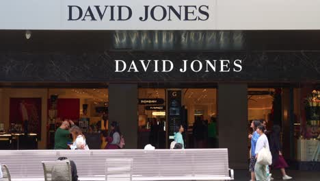 The-foot-traffic-of-David-Jones-flagship-storefront-in-bustling-downtown-Melbourne-city,-with-pedestrians-strolling-on-Bourke-Street-Mall-captured-in-slow-motion