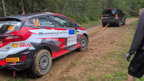 broken-down-wrc-car-is-tried-to-tow-away-but-it-wheels-have-been-stuck-and-are-not-rolling