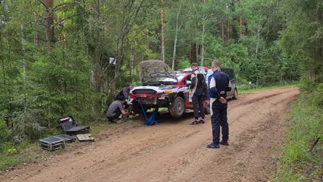 WRC-car-has-crashed-and-maintenance-guys-try-to-fix-problem-on-the-spot