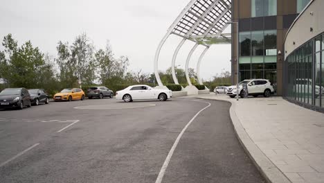 A-sophisticated-white-Rolls-Royce-is-gliding-past-the-parking-lot-of-a-prestigious-hotel