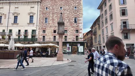 Large-city-square-with-market,-people,-restaurants,-ancient-sculptures-and-interesting-architecture,-Verona