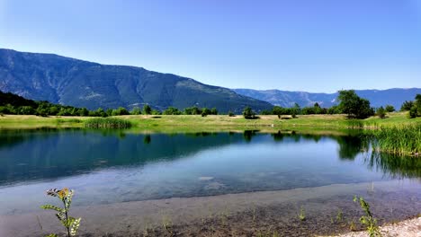 A-tranquil-lake-in-Crimea,-surrounded-by-lush-greenery-and-majestic-mountains