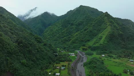 Teahupoo-Tahiti-French-Polynesia-aerial-drone-river-mountains-morning-grey-gray-raining-fog-season-wet-green-grass-end-of-the-road-point-faremahora-village-town-buildings-island-circle-right-motion