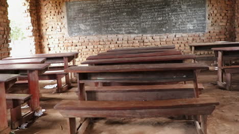Empty-classroom-with-wooden-desks-and-a-chalkboard-in-Kampala,-Uganda