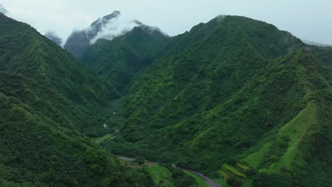Tahiti-French-Polynesia-Teahupoo-aerial-drone-raining-fog-mountain-peaks-river-morning-grey-gray-season-wet-green-Point-Faremahora-village-town-South-Pacific-Mount-Tohivea-island-backwards-pan-up