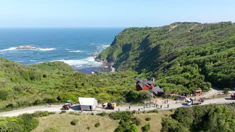 Vista-Aérea-Del-Tractor-Tirando-De-La-Casa-Al-Otro-Lado-De-La-Carretera-En-Chiloé,-Chile.