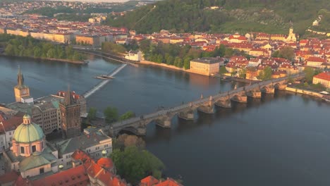 Vista-Aérea-De-Praga-Con-El-Puente-De-Carlos-Sobre-El-Río-Moldava,-El-Casco-Antiguo-Y-La-Ciudad-Pequeña-Con-Arquitecturas-Históricas-Y-Exuberante-Vegetación.