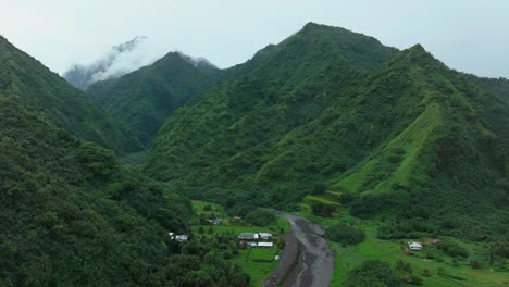 Teahupoo-Tahiti-French-Polynesia-aerial-drone-river-mountains-morning-grey-gray-raining-fog-season-wet-green-grass-end-of-the-road-Point-Faremahora-village-town-buildings-island-backwards-pan-reveal