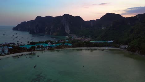 Luftaufnahme-Einer-Tropischen-Insel-In-Thailand-Mit-Resorts-Und-Booten-Bei-Sonnenuntergang-Mit-Dramatischem-Himmel