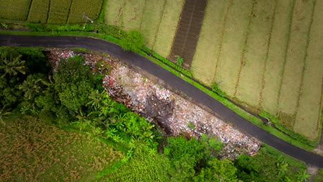 Top-view-of-smoldering-garbage-pile-next-to-country-road-in-Bali-countryside