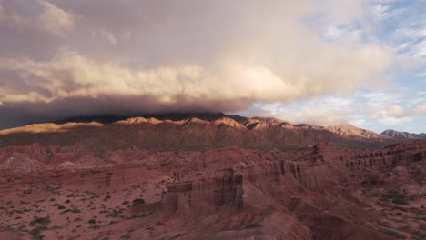 Majestätische-Drohnenaufnahmen-Bei-Sonnenuntergang-Des-Calchaquí-Tals-In-Salta,-Argentinien,-Zerklüftete-Landschaft-Mit-Dichten-Wolken,-Hügeln-Und-Roten-Felsformationen