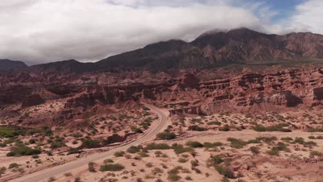 Stunning-aerial-view-of-the-Calchaquí-Valley,-Salta-Argentina,-a-road-and-a-mountain-as-a-backdrop