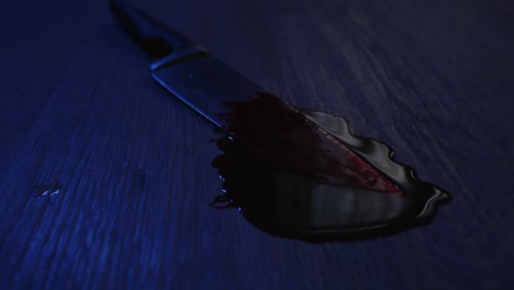A-sharp-kitchen-knife-covered-in-blood-lies-in-a-pool-of-blood-on-a-horrible-crime-scene