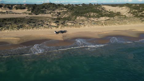 Vehicles-and-people-on-Preston-Beach,-Western-Australia,-in-a-scenic-orbit-shot