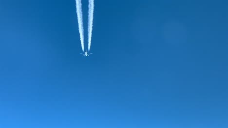 Immersive-pilot-POV-of-a-white-color-jet-and-its-wake-following-the-same-route-across-a-deep-blue-sky