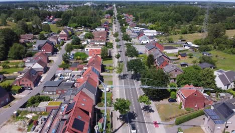 Vista-Aérea-Sobre-La-Zona-Suburbana-Belga-De-Mol-Con-Coches-Circulando-Por-Una-Carretera-Larga