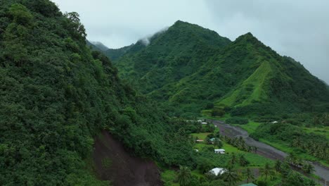 Rainy-Mountains-Teahupoo-Tahiti-French-Polynesia-aerial-drone-fog-morning-grey-gray-raining-season-wet-green-grass-end-of-the-road-point-faremahora-village-town-buildings-island-circle-right
