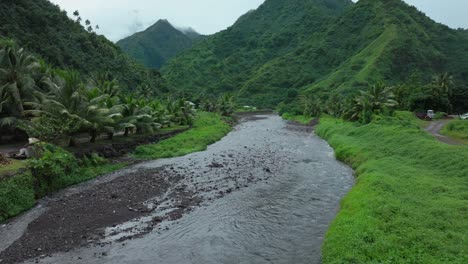 Teahupoo-Tahiti-French-Polynesia-aerial-drone-mountains-morning-grey-gray-raining-fog-season-wet-green-grass-end-of-the-road-Point-Faremahora-village-town-buildings-island-backwards-pan-up-reveal
