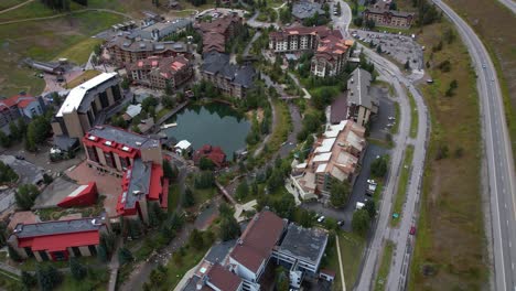 Vista-Aérea-De-La-Estación-De-Esquí-Copper-Mountain-En-Temporada-De-Verano,-Hoteles-Y-Edificios-De-Apartamentos-Por-La-Autopista-Interestatal,-Colorado,-EE.UU.