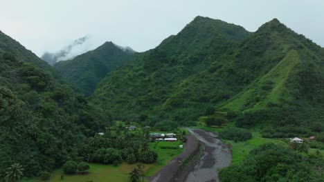 Teahupoo-Tahiti-French-Polynesia-aerial-drone-river-mountains-morning-grey-gray-raining-fog-season-wet-green-grass-end-of-the-road-Point-Faremahora-village-town-buildings-island-upwards-motion