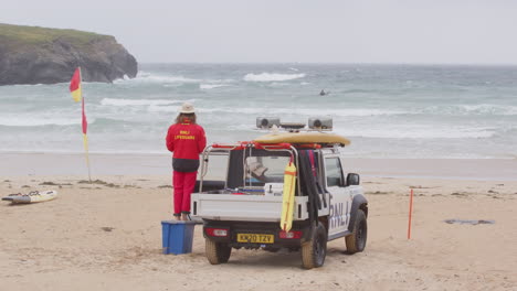 Un-Socorrista-De-Rnli-Vestido-De-Rojo-Junto-A-Un-Camión-Patrulla-De-Playa-Vigila-A-Los-Surfistas