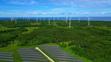 Aerial-drone-panning-shot-over-solar-panels-and-windmills-in-Paldiski-Windmill-park,-Pakri-peninsula,-Estonia,-Europe-on-a-sunny-day