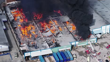 Telephoto-drone-shot-of-a-burning-building-in-flames,-sunny-day-in-Mexico-city