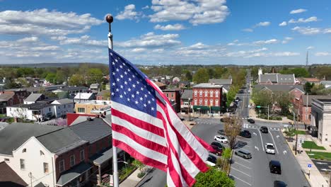 Patriotic-American-flag-waves-over-small-town-in-USA