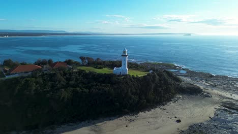 Drone-aerial-landscape-of-Norah-Head-Lighthouse-beacon-tower-buildings-architecture-maritime-bushland-cliff-hill-coastline-Central-Coast-Australia-travel-tourism