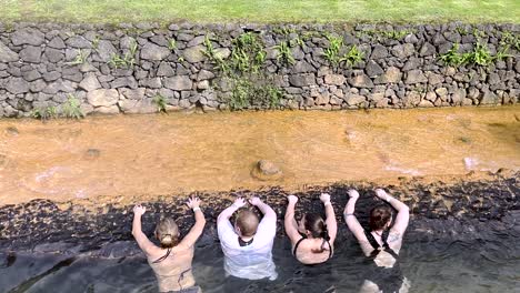 Gente-Detrás-Relajándose-En-El-Agua-En-Un-Manantial-En-Medio-Del-Campo