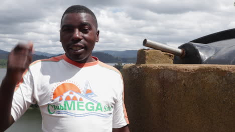 Man-explaining-rainwater-harvesting-system-in-a-rural-area-with-a-scenic-backdrop