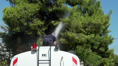 Imágenes-En-Cámara-Lenta-Y-Vista-Posterior-Del-Equipo-Municipal-De-Kifissia,-Grecia,-Ahorrando-Agua-A-Presión-En-Los-Pinos-Para-Evitar-La-Propagación-De-Incendios-Forestales