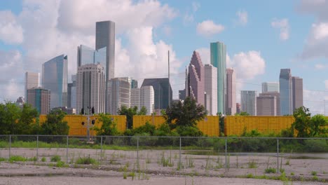 Establishing-shot-of-downtown-Houston,-Texas-on-cloudy-but-sunny-day-as-train-passes-by