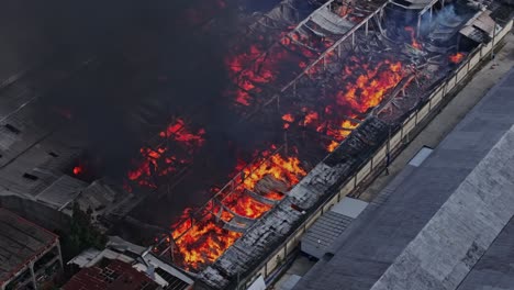 Infierno-Con-Llamas-Al-Rojo-Vivo-Asola-El-Almacén-De-La-Fábrica-En-Una-Zona-Industrial,-Aéreo