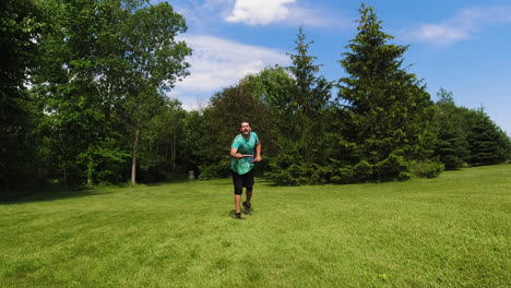 A-man-throws-a-disc-in-an-open-grassy-field,-aiming-for-the-distant-basket-on-a-bright,-sunny-day,-exemplifying-the-freedom-and-skill-of-disc-golf