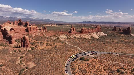 Aerial-view-of-Utah's-desert-landscape-with-striking-red-rock-formations,-showcasing-the-vast-and-rugged-beauty-of-the-region