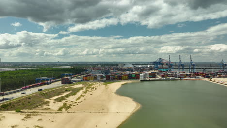 Aerial-view-of-an-industrial-port-area-with-cranes-and-containers-near-a-sandy-beach---Gdańsk-main-Harbor---T3