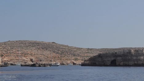 Boats-anchored-near-the-coastline-of-Malta-on-a-sunny-summer-day,-embodying-the-spirit-of-travel-and-vacation