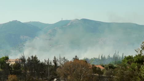 Helicóptero-Bombero-Rociando-Agua-Sobre-Un-Gran-Incendio-Forestal-En-El-Bosque-De-Parnitha,-Grecia