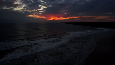 Puesta-De-Sol-Roja-Detrás-De-Nubes-Oscuras-En-La-Playa-Oeste-De-Agua-Dulce-En-Pembrokeshire,-Gales