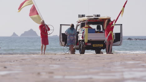 Lifeguards-on-beach-pack-away-flags-and-gear-into-jeep-at-end-of-day