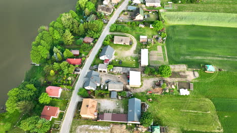 Aerial-view-of-a-small-village-with-houses,-gardens,-and-fields