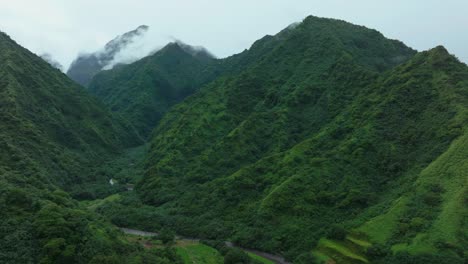 Tahiti-French-Polynesia-Teahupoo-aerial-drone-raining-fog-mountain-peaks-river-morning-grey-gray-season-wet-green-Point-Faremahora-village-town-South-Pacific-Mount-Tohivea-island-upwards-motion