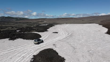 SUV-driving-around-glacier-aerial-view