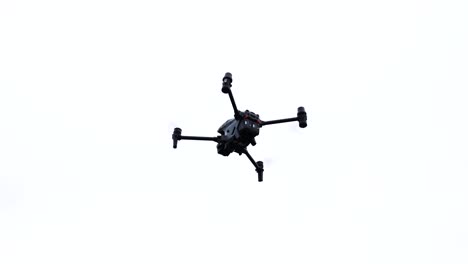 High-performance-drone-silhouette-hover-in-bright-white-sky,-Czechia