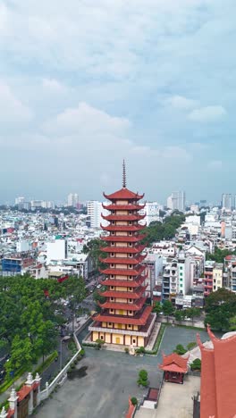 Vertikaler-Hyperlapse-Einer-Buddhistischen-Pagode-In-Ho-Chi-Minh-Stadt,-Vietnam-Mit-Gebetsturm-Und-Rotem-Dach-In-Einem-Dicht-Besiedelten-Gebiet-Der-Stadt