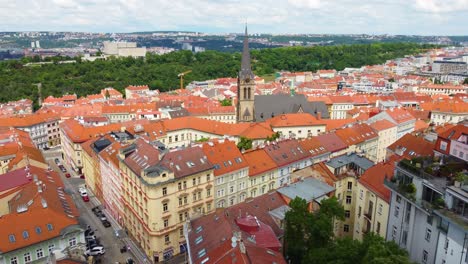 Praga,-República-Checa,-Con-Tejados-De-Tejas-Rojas,-Edificios-Históricos-Y-Una-Iglesia-Con-Una-Alta-Aguja.