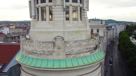 Aerial-view-of-a-historic-building-with-a-tower-in-Vienna,-Austria,-featuring-intricate-architectural-details-and-a-cityscape-in-the-background