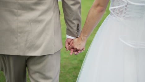 Un-Momento-Conmovedor-Capturado-Cuando-Una-Pareja-De-Recién-Casados-Se-Toma-De-La-Mano-El-Día-De-Su-Boda,-Simbolizando-El-Amor,-La-Unidad-Y-El-Comienzo-De-Un-Nuevo-Viaje-Juntos.