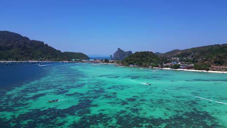 Vista-Aérea-De-La-Isla-Phi-Phi-Con-Aguas-Turquesas,-Barcos,-Complejos-Turísticos-De-Lujo-Y-Paisajes-Montañosos